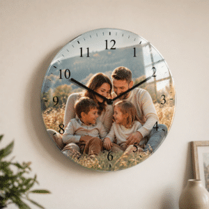 Decorative wall clock featuring a smiling family portrait on the clock face, with black hands over a field setting.